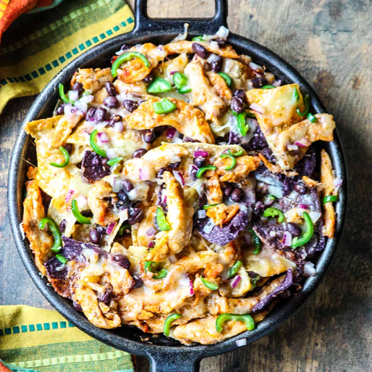 The finished leftover turkey nachos in a cast iron pan ready to eat.
